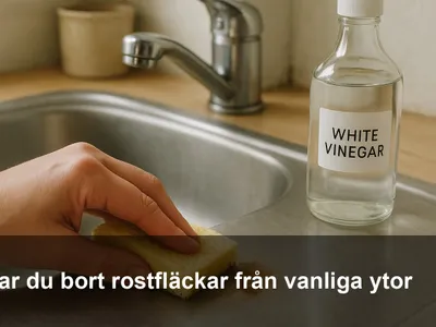Hand som tar bort en liten rostfläck på en diskho av rostfritt stål med mjuk svamp och ättika.