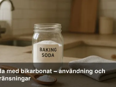 En burk bikarbonat med sked och en mjuk trasa på köksbänk, redo för städning.