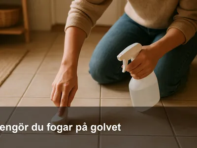 Hand som skrubbar golvfogar mellan klinker med en liten borste och rengöringslösning