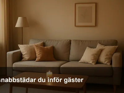 Snabbstädat vardagsrum med fluffade kuddar, rent soffbord och varm belysning inför gäster.