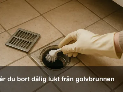 Närbild på en person med handskar som lyfter gallret till en golvbrunn och borstar rent.