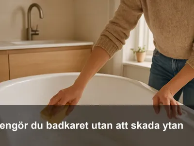 Hand som rengör ett vitt badkar med mjuk svamp och milt skum.